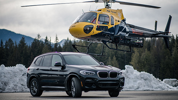 BMW steht vor landendem Helikopter in Kanada